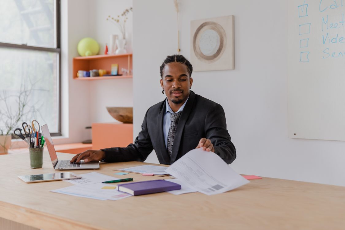 A Black business owner reviewing documents at his desk